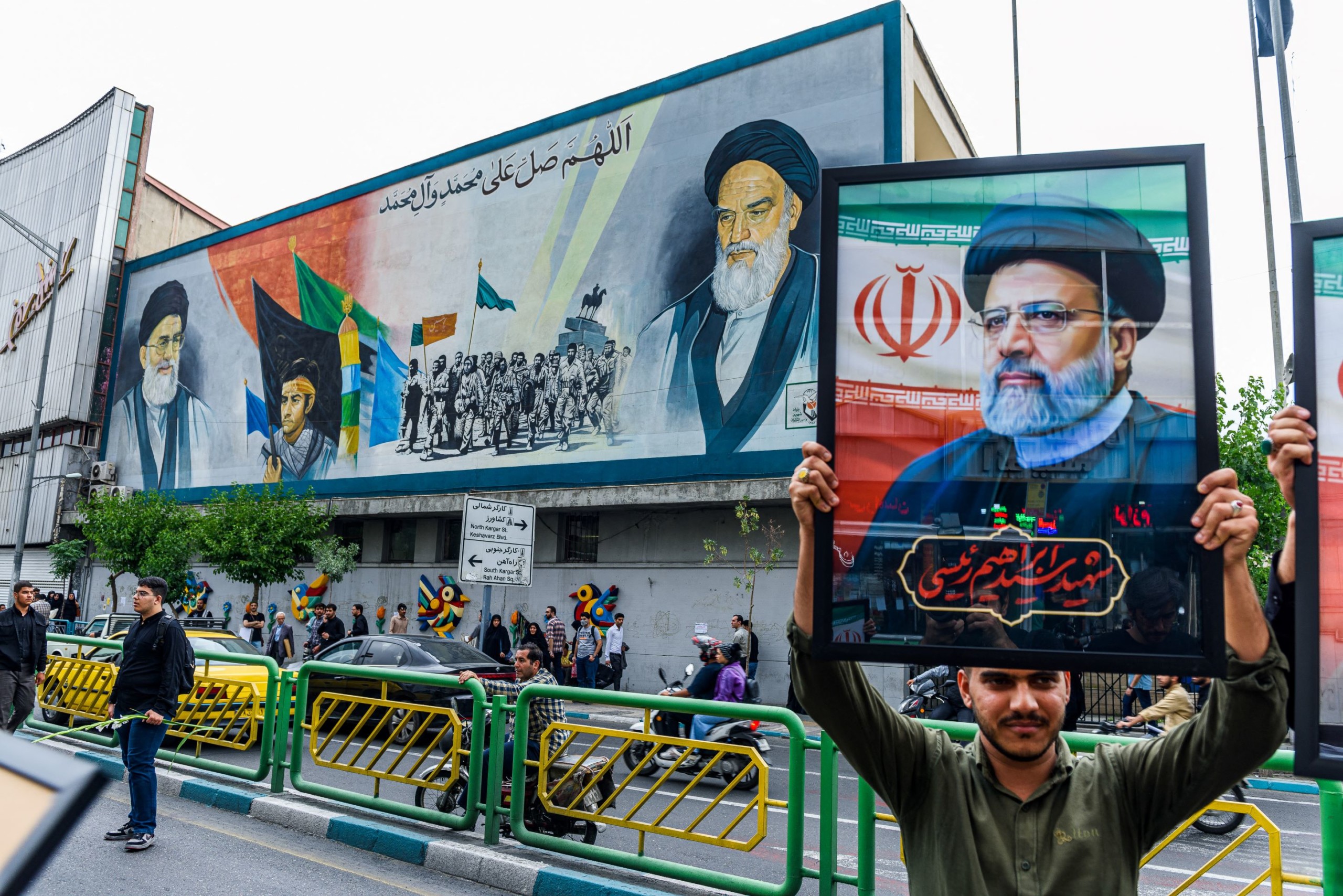 Egy gyászoló Ebrahím Raíszi arcképét tartja Teheránban, május 21-én.
