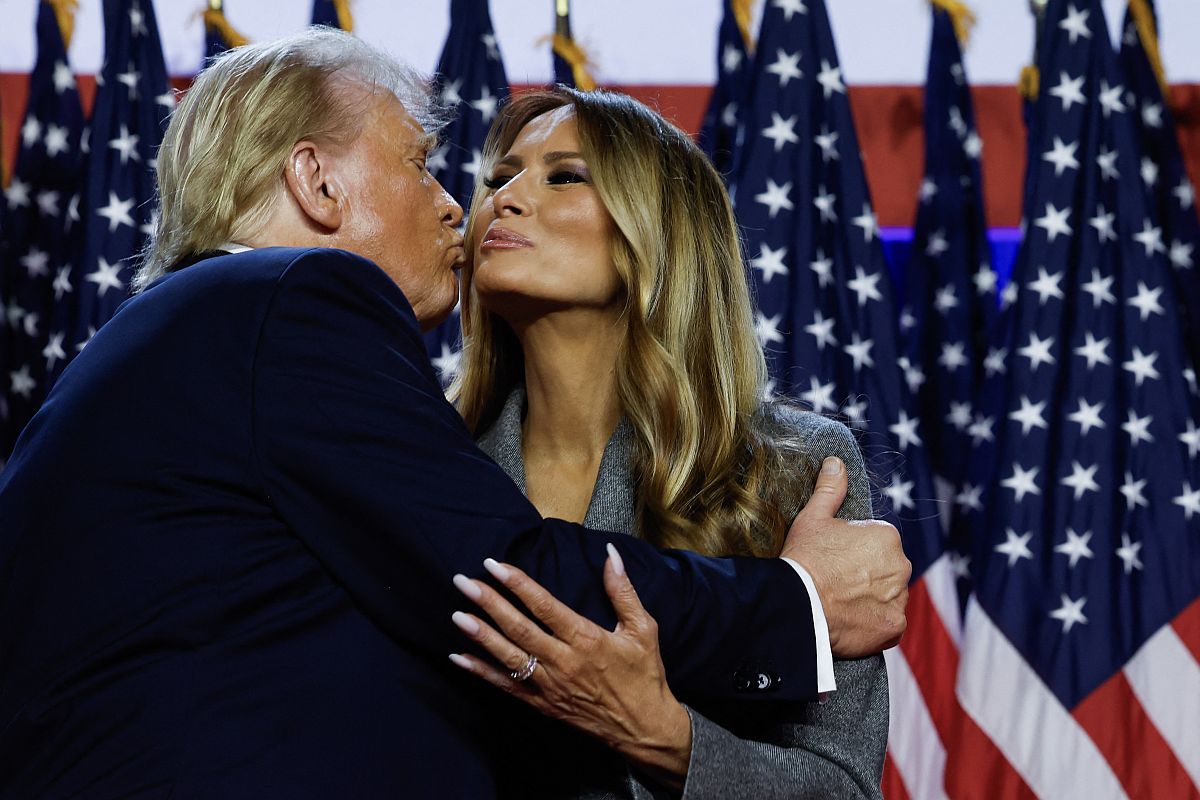 Donald Trump és Melania Trump puszit adnak egymás arcára.