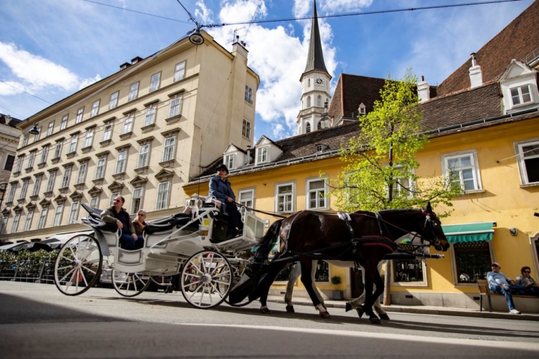 Turisták túráznak lovaskocsin Bécsben, Ausztriában