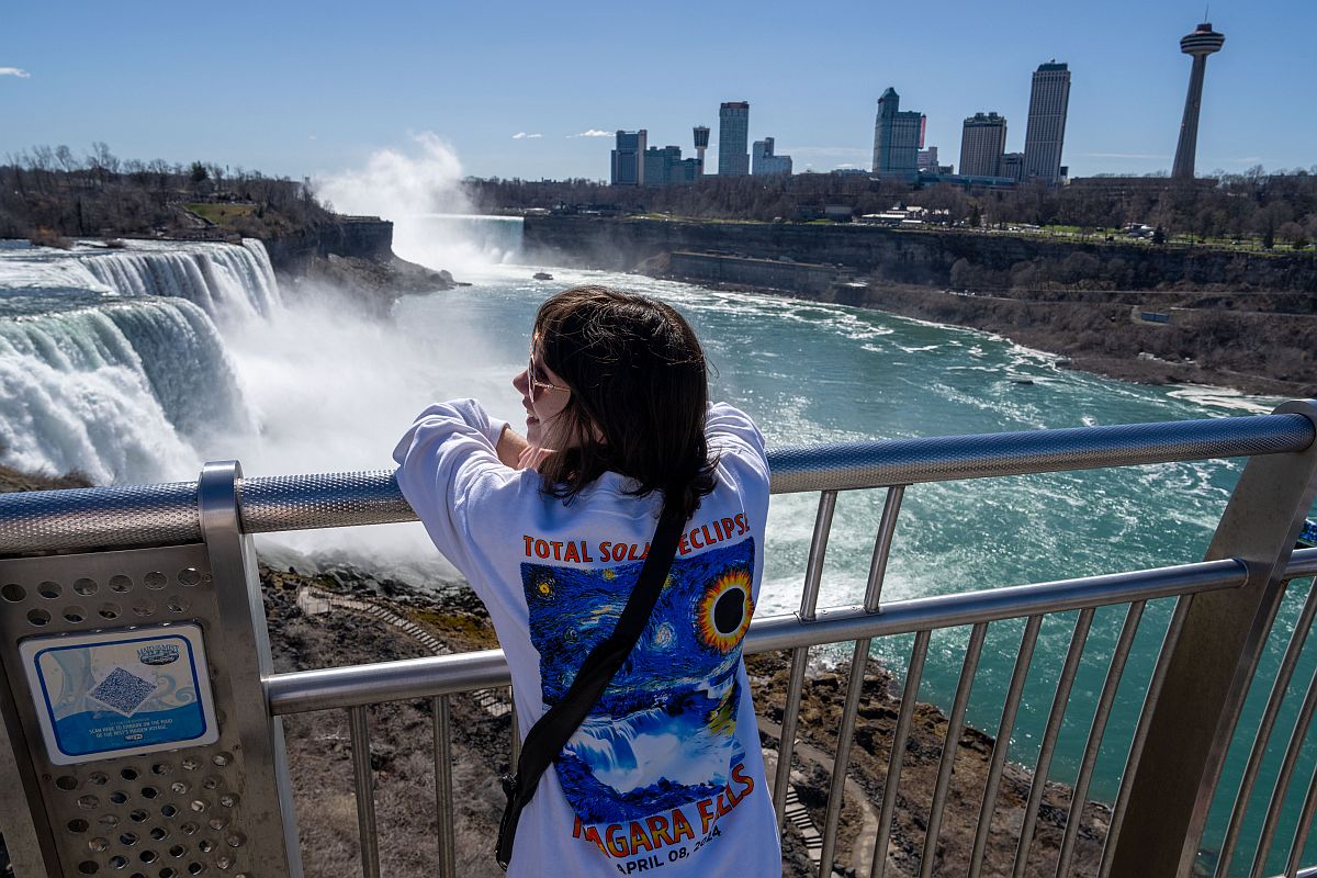 Napfogyatkozást ábrázoló pólóban egy nő a Niagara-vízesésnél.