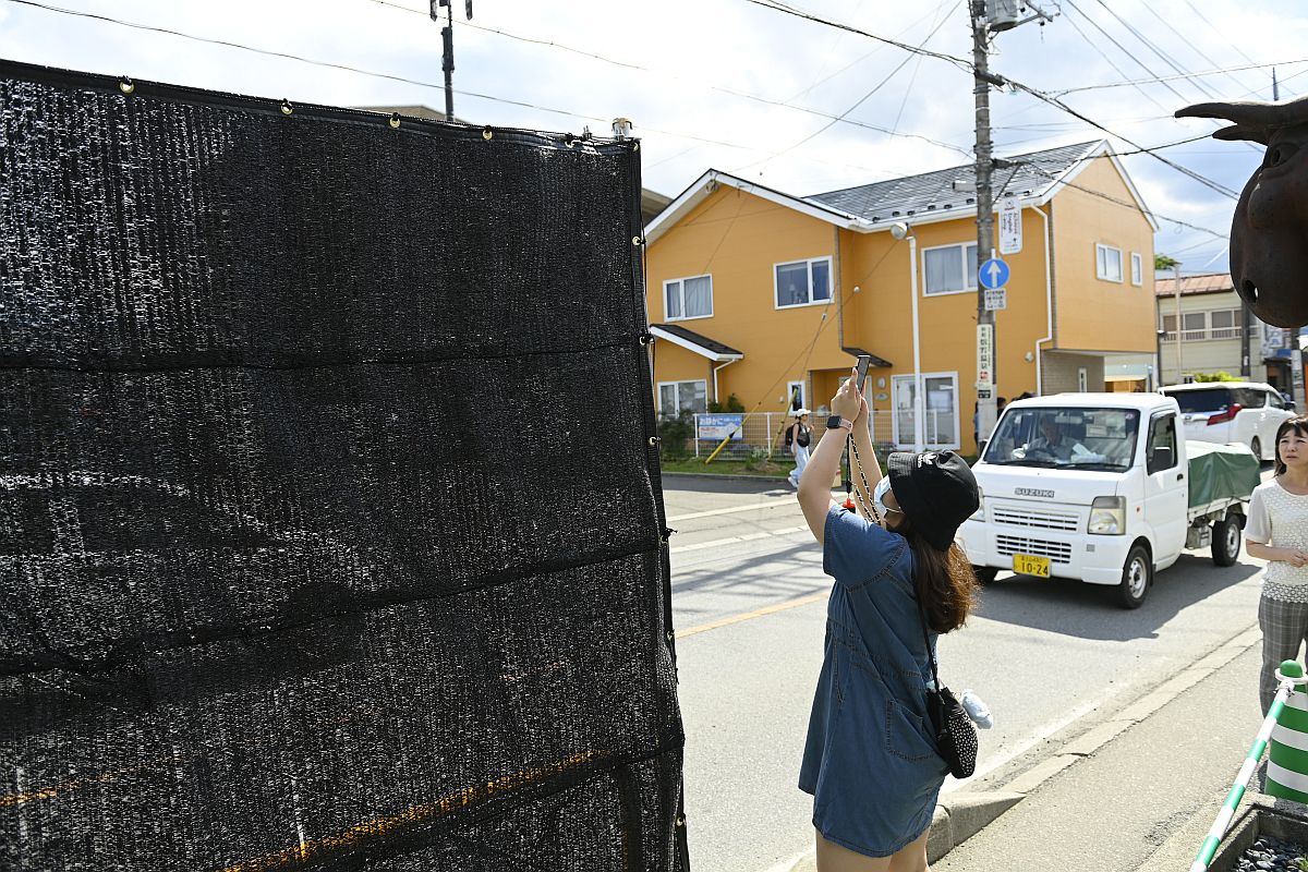 A Fudzsira néző kilátást akadályozó kerítést épít egy munkás a Fudzsikavagucsikóban fekvő Lawson-üzlet elé 2024. május 21-én.