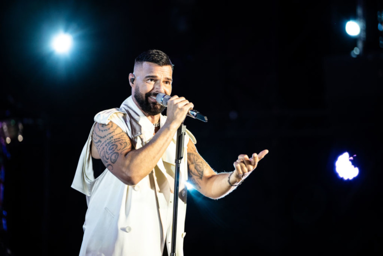 Ricky Martin énekel mikrofonnal a kezében fehér ruhában