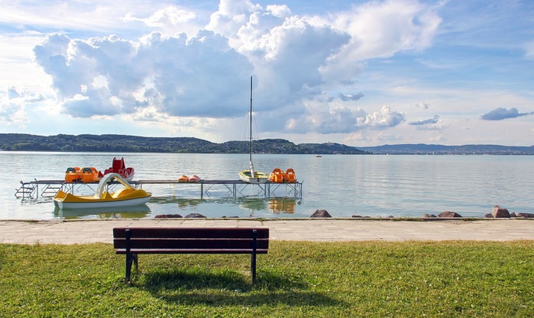 Vízibiciklik a Balatonban, egy pad a parton.