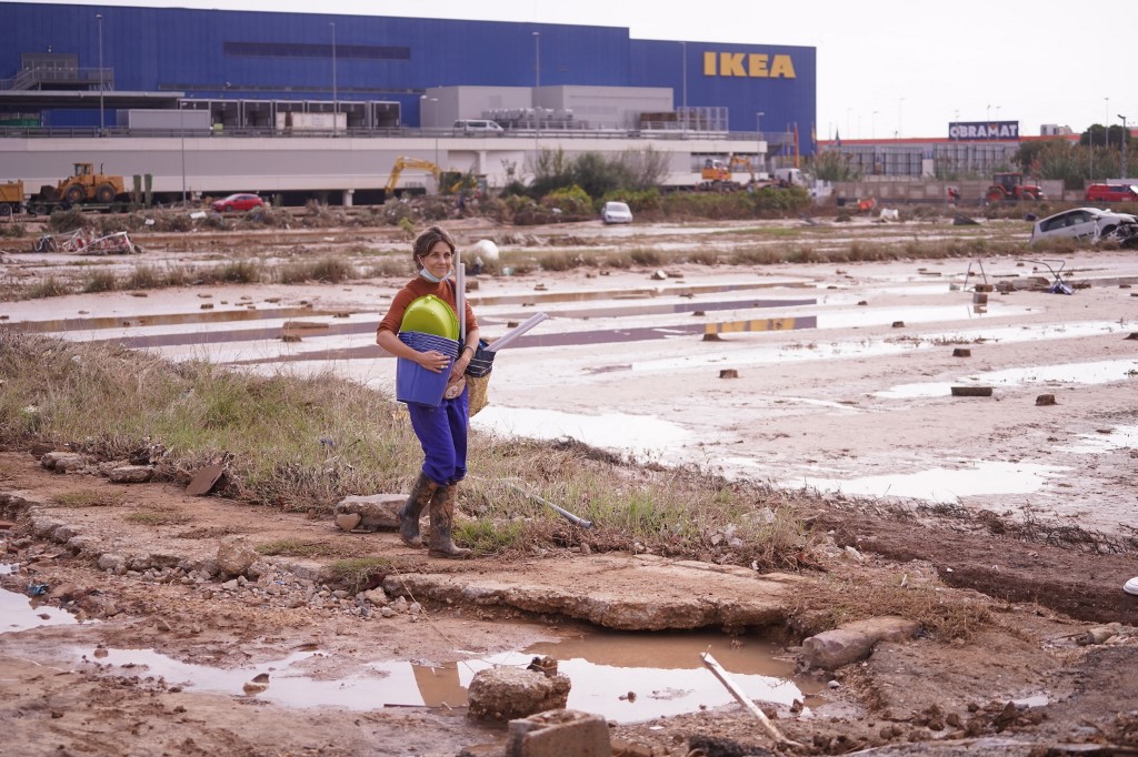 Az ikea előtt áll egy nő az áradás nyomai a háttérben