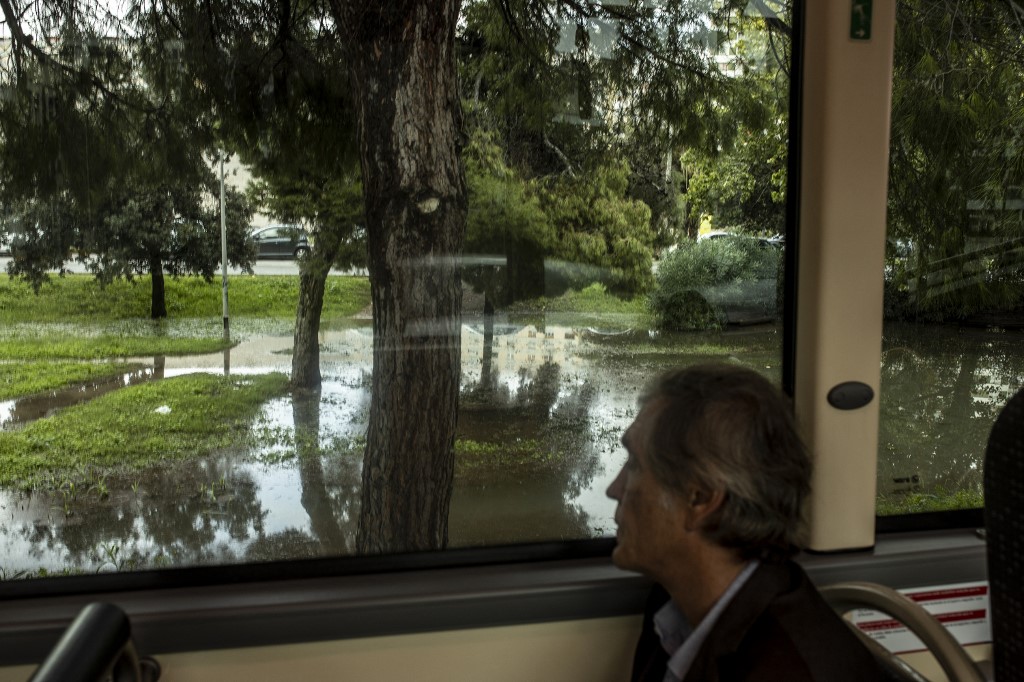 Idős férfi ül az ablaknál és nézi az elárasztott utcát