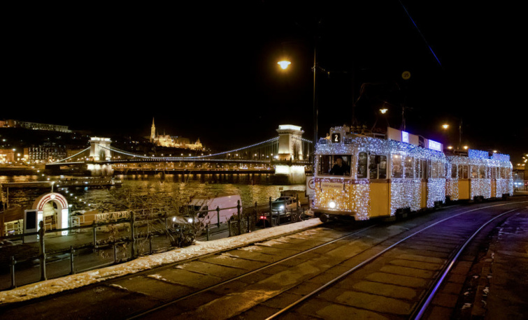 Fényvillamos Budapesten, háttérben a kivilágított Erzsébet híd