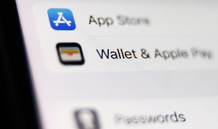 Apple Wallet logó és felirat egy mobiltelefon képernyőjén.
