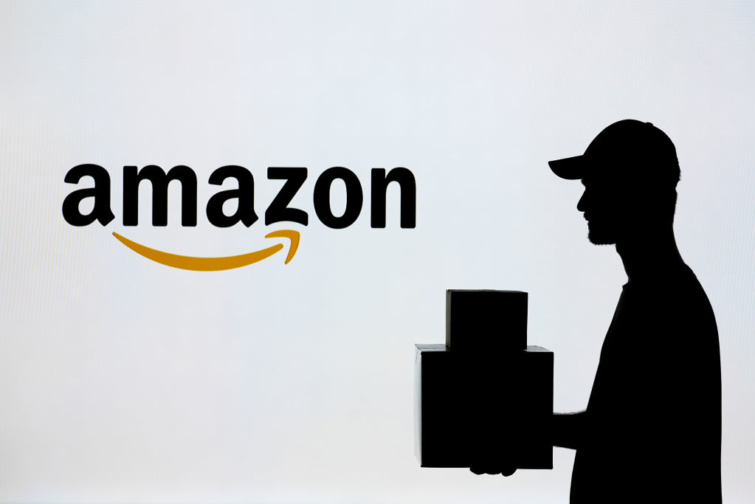 Amazon logó és mellette kiszállító sziluettje csomagokkal